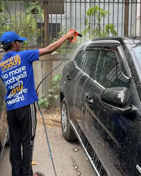 Washer foaming a black SUV, shirt reads No more pochaa, wash only pressure wash